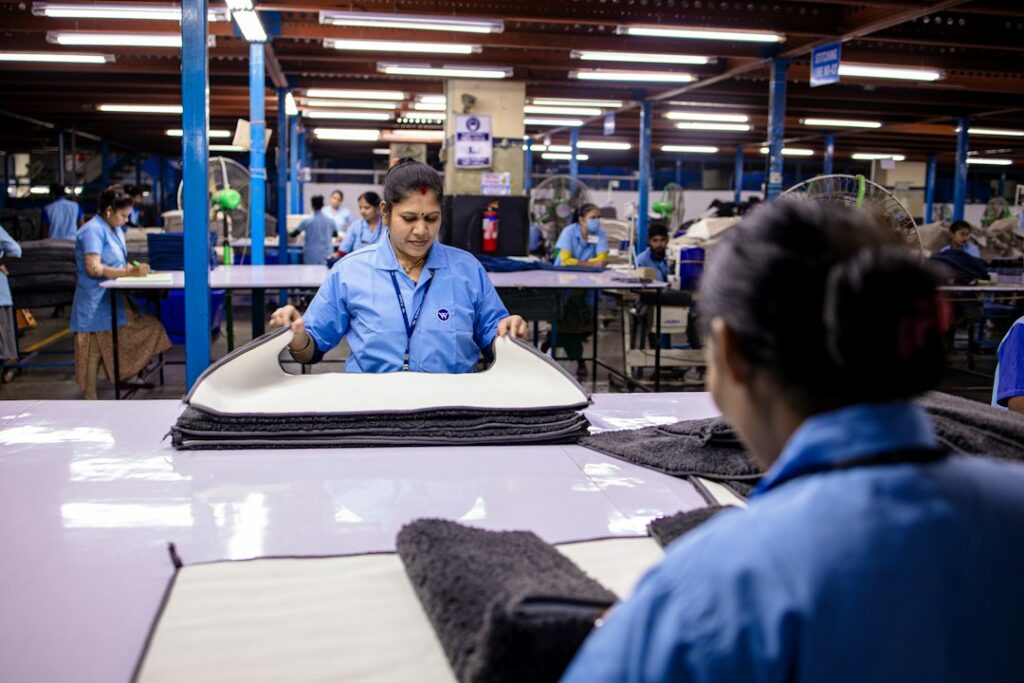 Workers assembling products on a factory floor, representing the operations an interim head of quality steps in to support